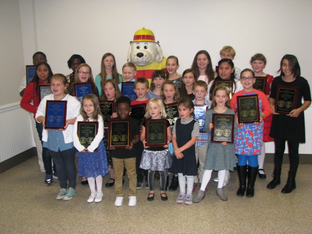 Fire Prevention Poster and Essay Contest winners shown are in back (l-r) Staqhuan Clanton, Kiarra Weston-Bagwell, Madison James, Sparky, Allison Swartzentruber, Sophia Littleton, Caleb Rodgers, Kaitlyn Johnson, and Evelyn Mancilla-Torres. In the third row are Alison Swartz, Samuel Winston, Carolyn Reese, Alyson Adams and Paola Rodriguez-Herrera. In the second row are Adela Martin, Evangeline Hoban, Colt Carley, Somer Layton, Colton Brennan and Emily Peterson. In front are Sophia Ferris, Skyler Richards, Khalil Miles, Savannah Montizer, Emily Morris and Claire Denham. SUBMITTED PHOTO